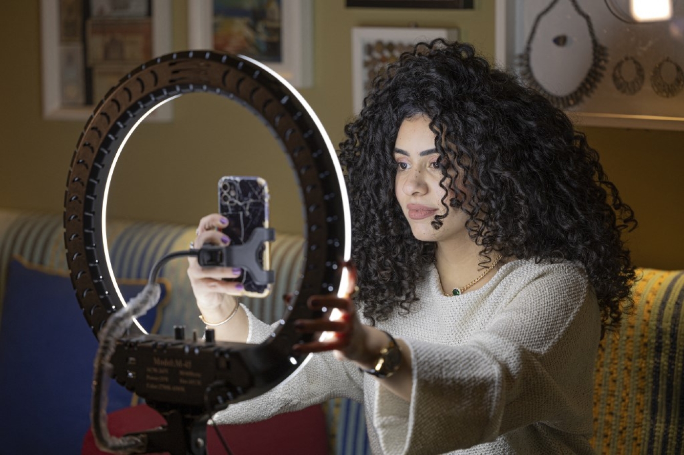 Mariam Ashraf, enseignante et « influenceuse des cheveux naturels », fait un direct chez elle au Caire, le 22 mars 2022 (AFP/Khaled Desouki)