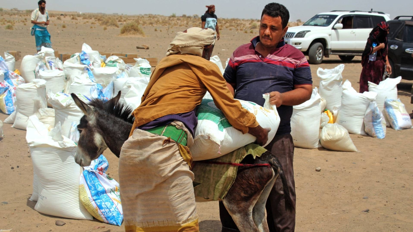 Yemeni families receive flour rations and other basic food supplies like rice, oil and sugar, from charities in the province of Lahj, in southern Yemen, on 29 March 2022.