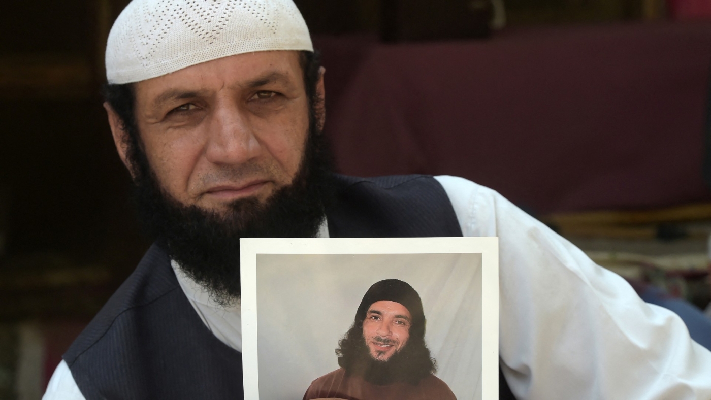 Roman Khan holding a photo of his brother, Assadullah Haroon Gul, who was held at Guantanamo for 15 years without charge.