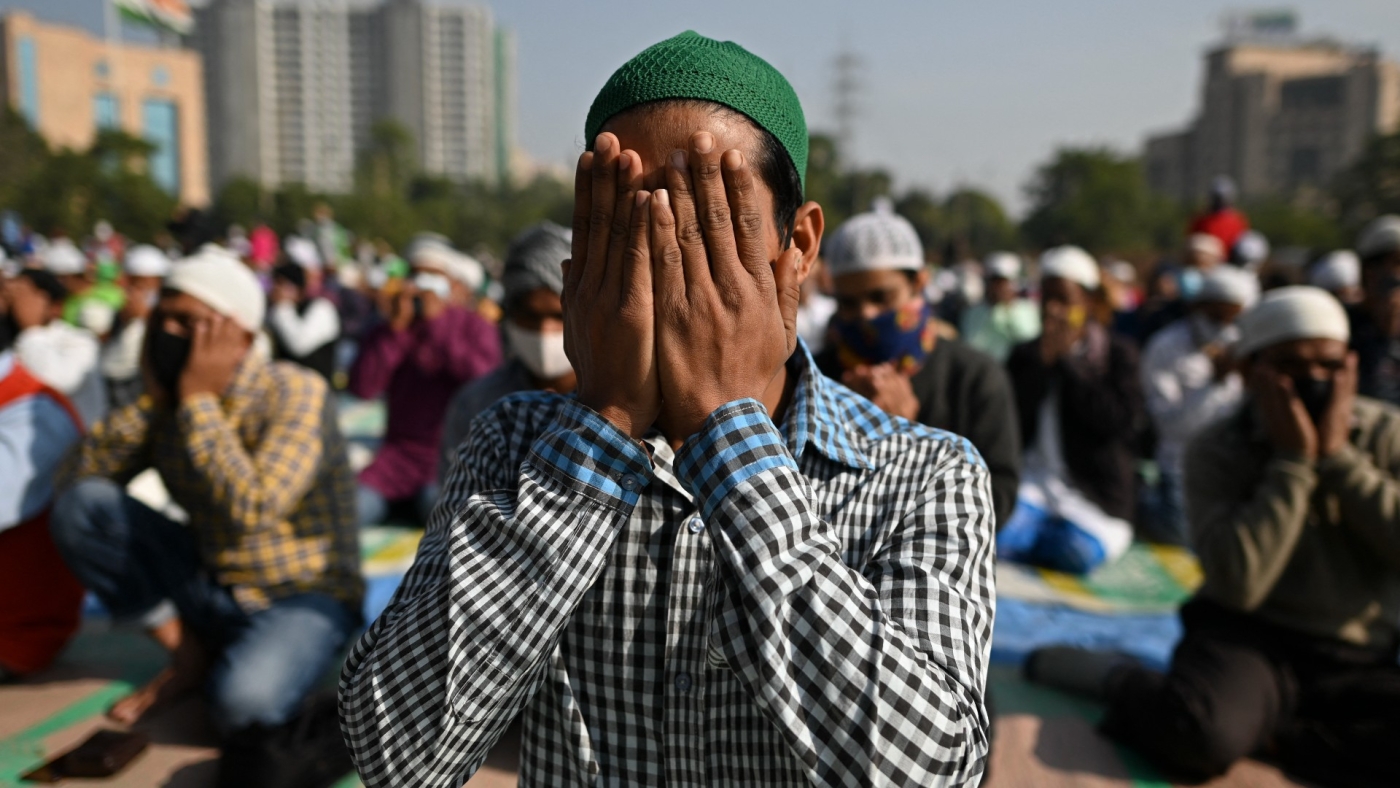 Muslim devotees offer Friday prayers in an open ground in Gurgaon on the outskirts of New Delhi on 17 December, 2021 (AFP)