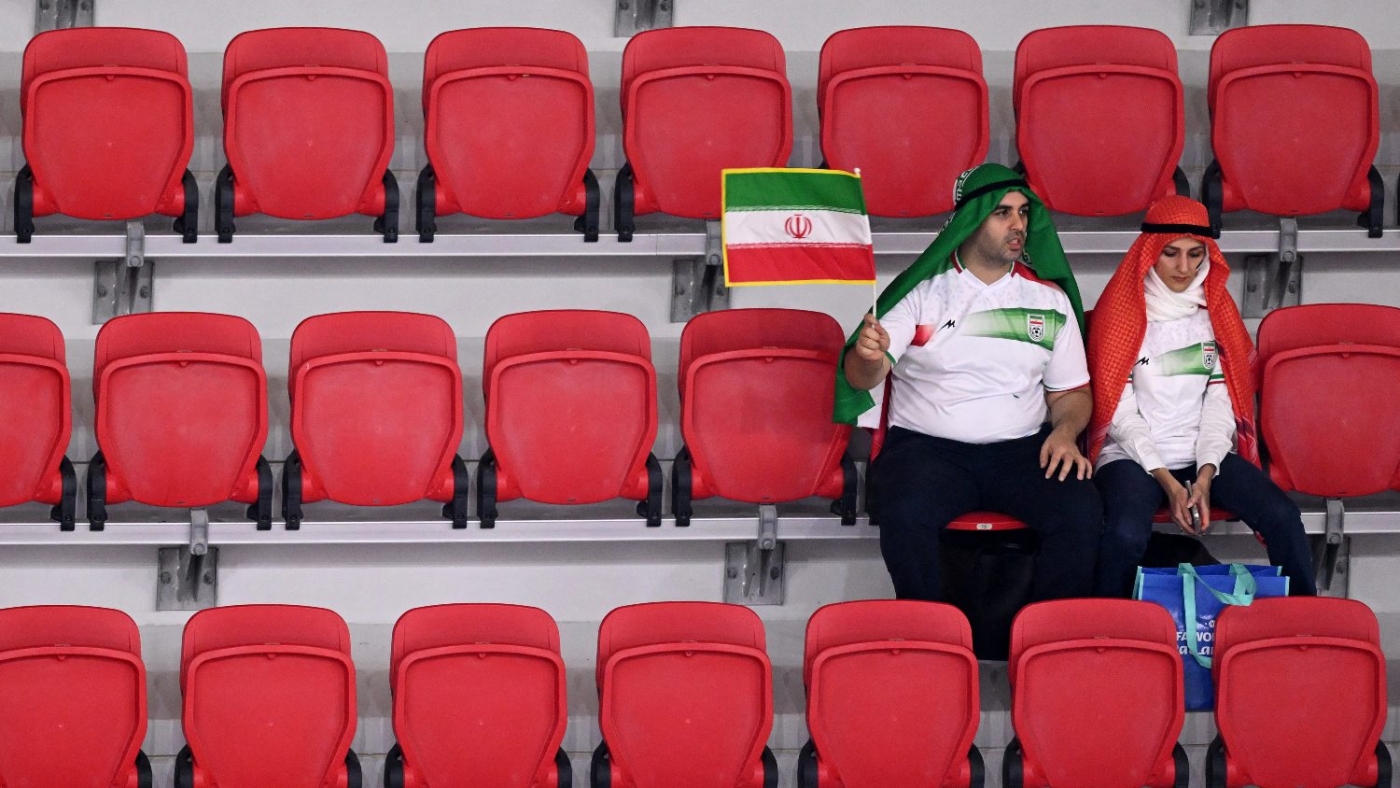 Iran fans wave an Iranian flag as they wait in their seats for kick-off ahead of the Qatar 2022 World Cup Group B football match between Iran and USA in Doha on 29 November 2022.