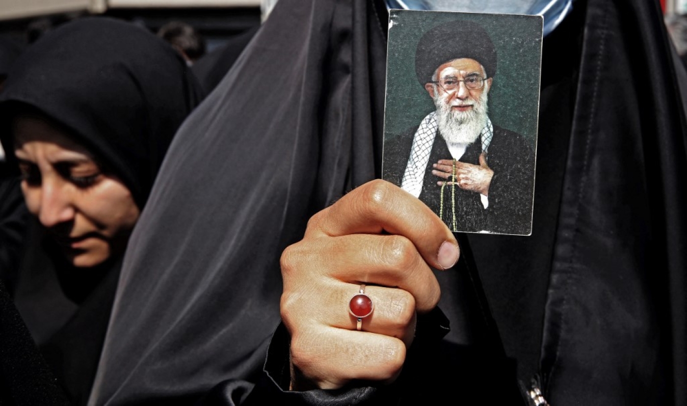 Une Iranienne brandit le portrait du guide suprême Ali Khamenei lors d’une manifestation pro-hijab, le 23 septembre 2022 à Téhéran (AFP)