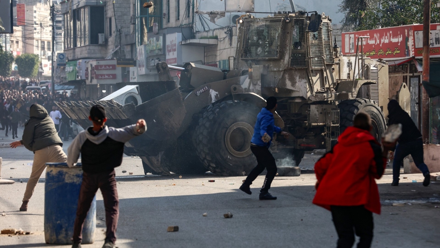 Des Palestiniens lancent des pierres sur un bulldozer de l’armée lors d’un raid israélien meurtrier dans la ville de Jénine