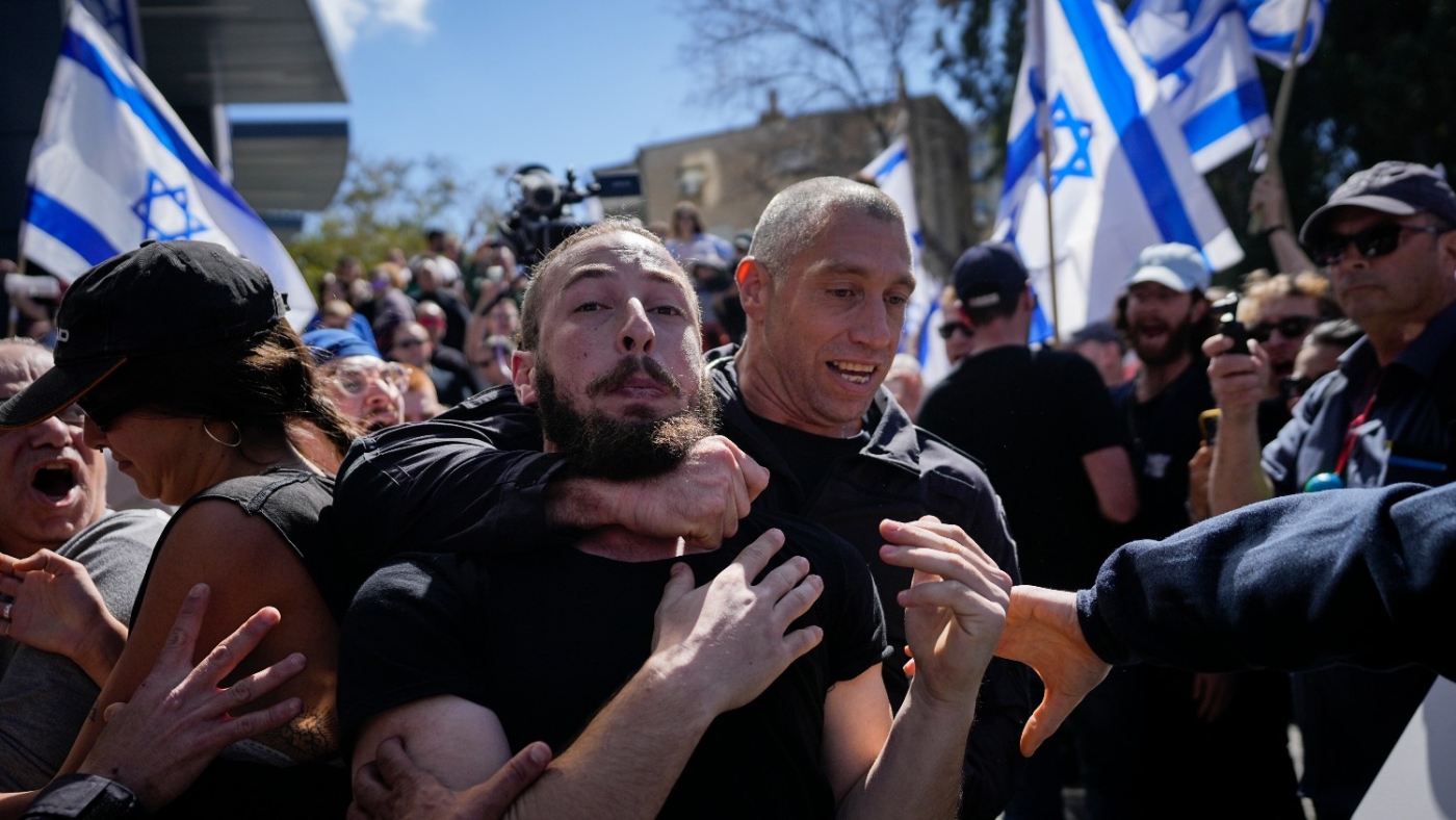 An Israeli police officer grabs a protester during a protest against plans by Prime Minister Benjamin Netanyahu's new government to overhaul the judicial system Tel Aviv on 9 March 2023.
