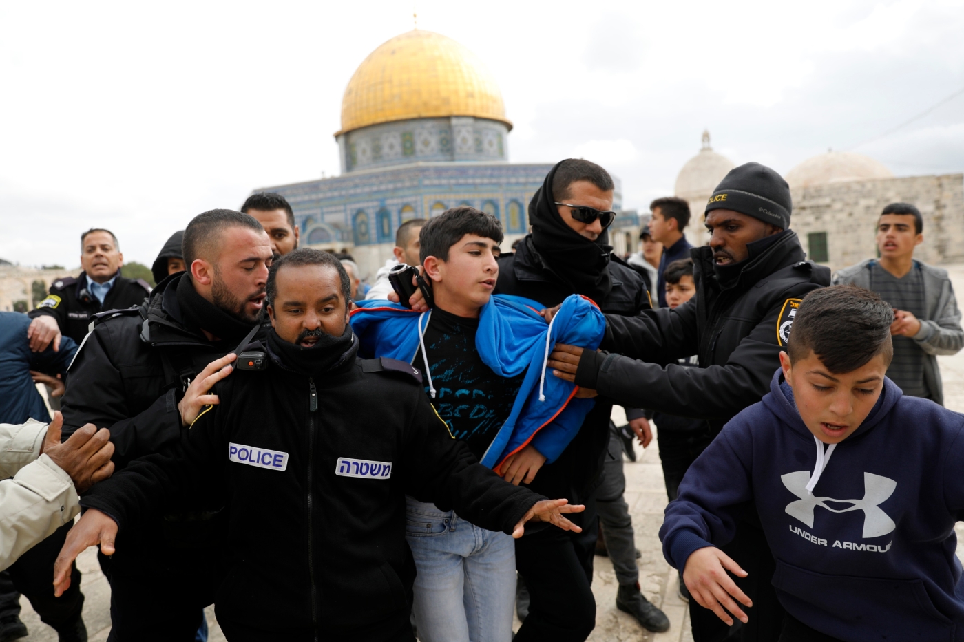Israeli policemen detain a young Palestinian demonstrator after protesters tried to break the lock on a gate at the al-Aqsa mosque compound in Jerusalem's Old City on 18 February 2019 (AFP)