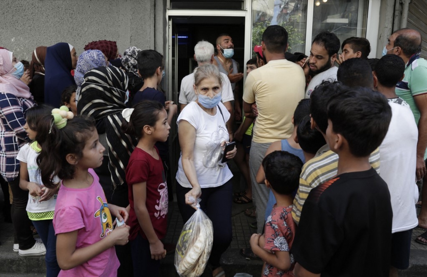 People wait in line at a bakery in the southern suburbs of Lebanon's Beirut on 13 August 2021, amidst a shortage of basic items due to a severe economic crisis.