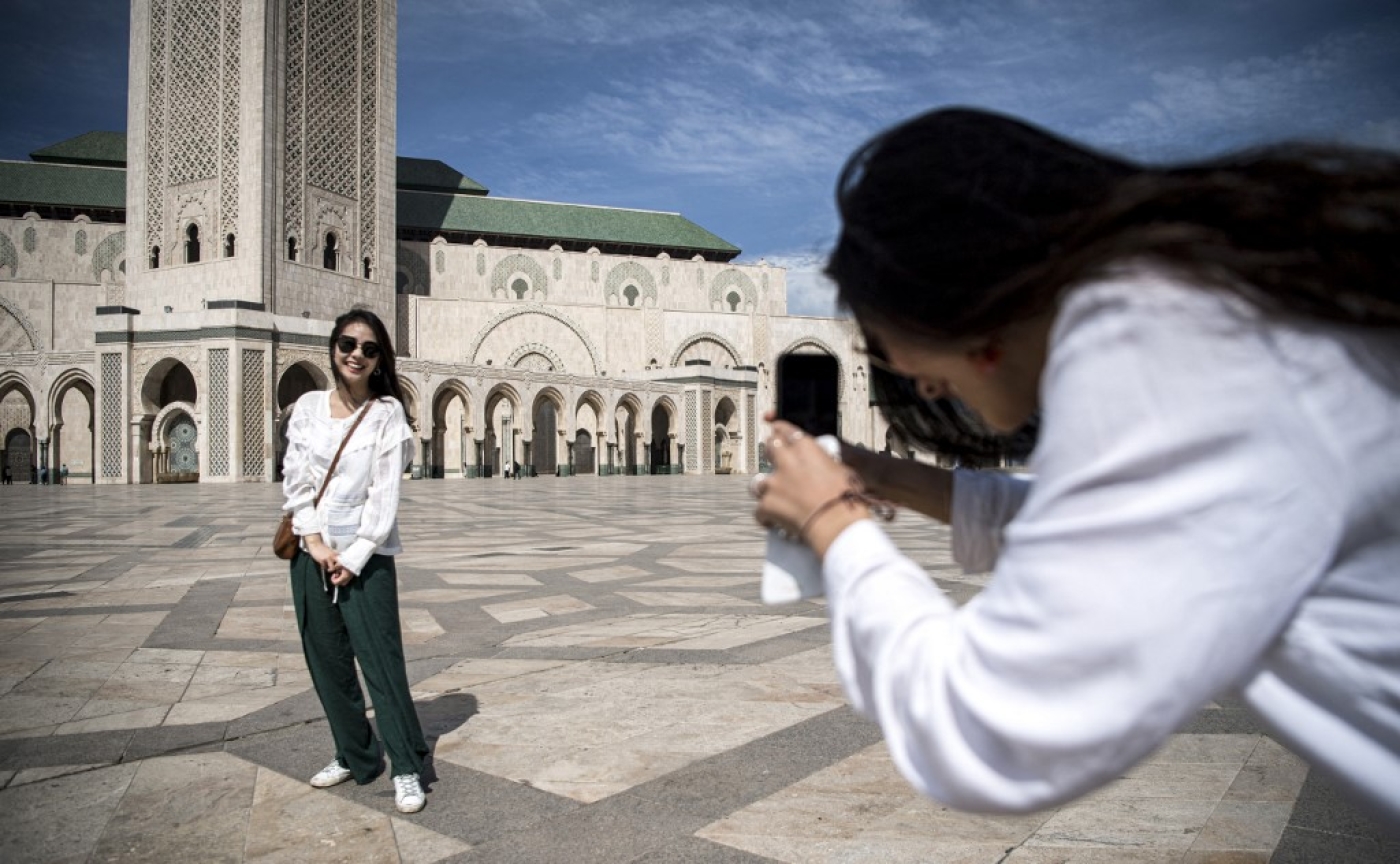 Des touristes se prennent en photo devant la mosquée Hassan II à Casablanca (AFP/Fadel Senna)