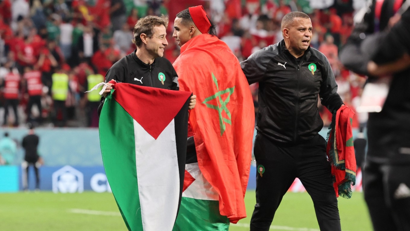 A member of Morocco's team holds a Palestinian flag after the team defeated Spain on 6 December 2022.