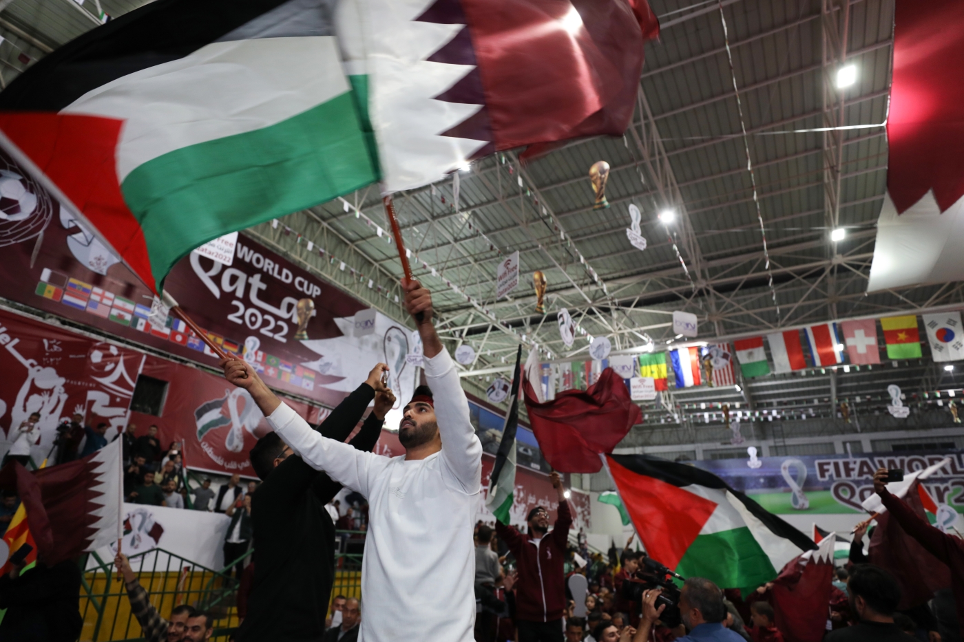 Fans wave the Qatari and Palestinian flags in Gaza city on November 20, the day of the opening ceremony (Reuters)