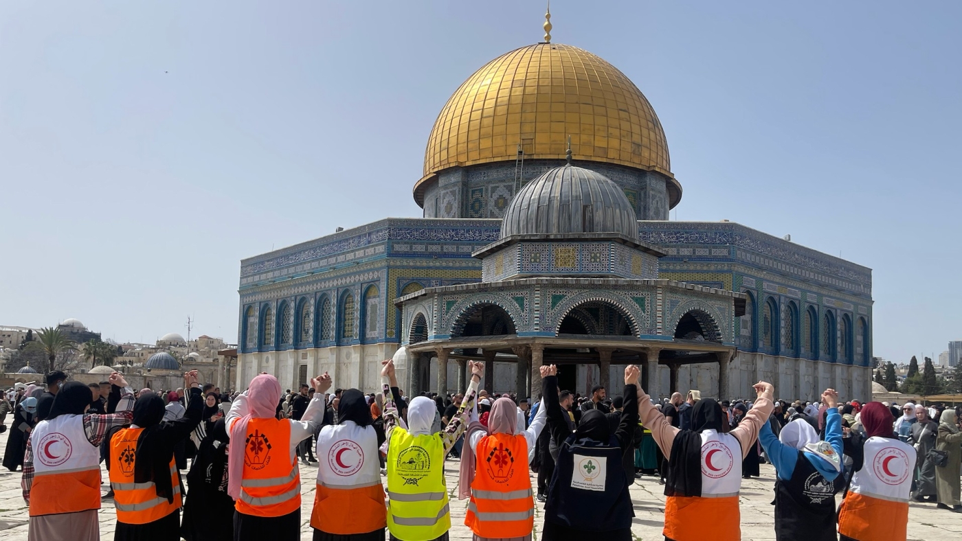 Palestinian scouts and Palestinian Red Crescent workers join hands to protect people during prayers at the al-Aqsa mosque (MEE)