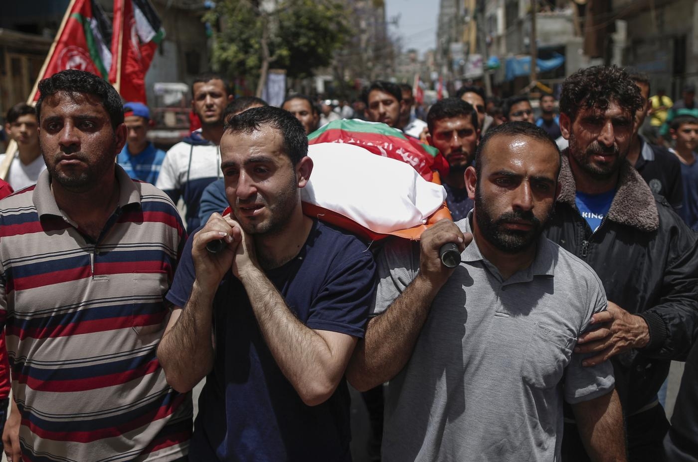 Relatives carry the body of a Palestinian, who was killed in Israeli strikes the previous day, during a funeral ceremony in Beit Lahia, in northern Gaza Strip (AFP)