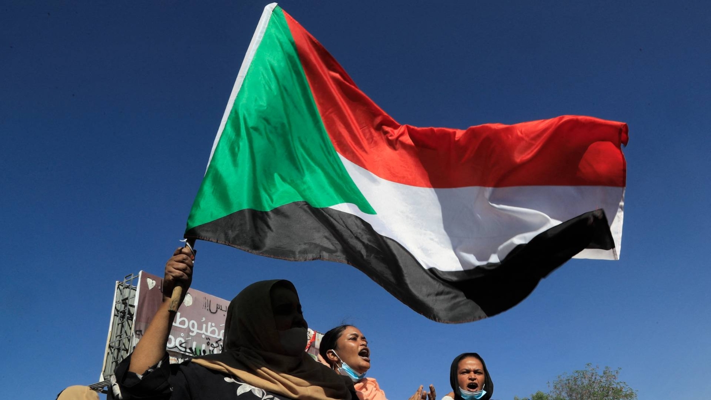 A Sudanese anti-coup protester waves the national flag during a demonstration in east Khartoum on 25 November 2021