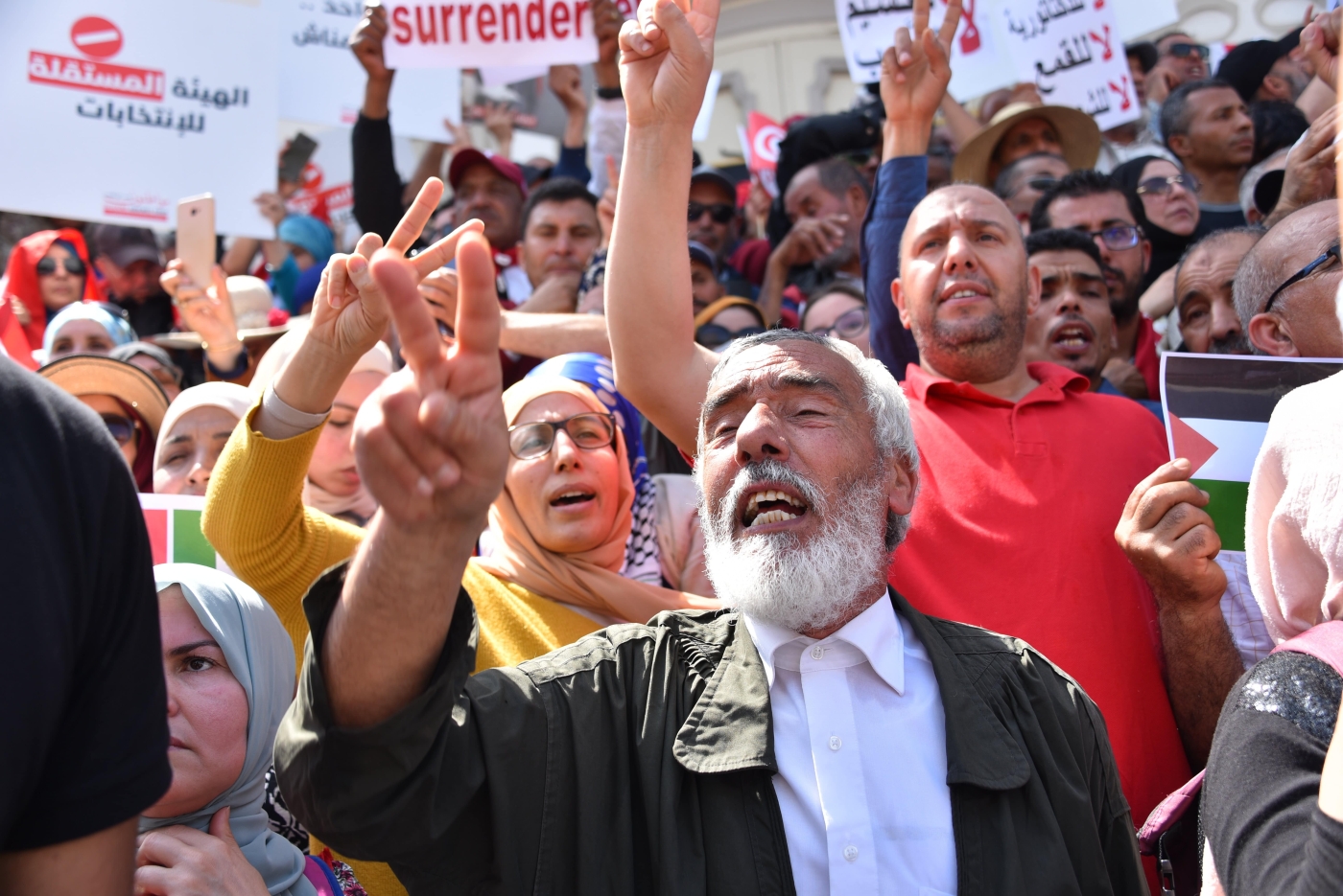 Tunisian protesters wave flags and rase placards as they demonstrate against their president in the capital Tunis, on 15 May 2022. (Reuters)