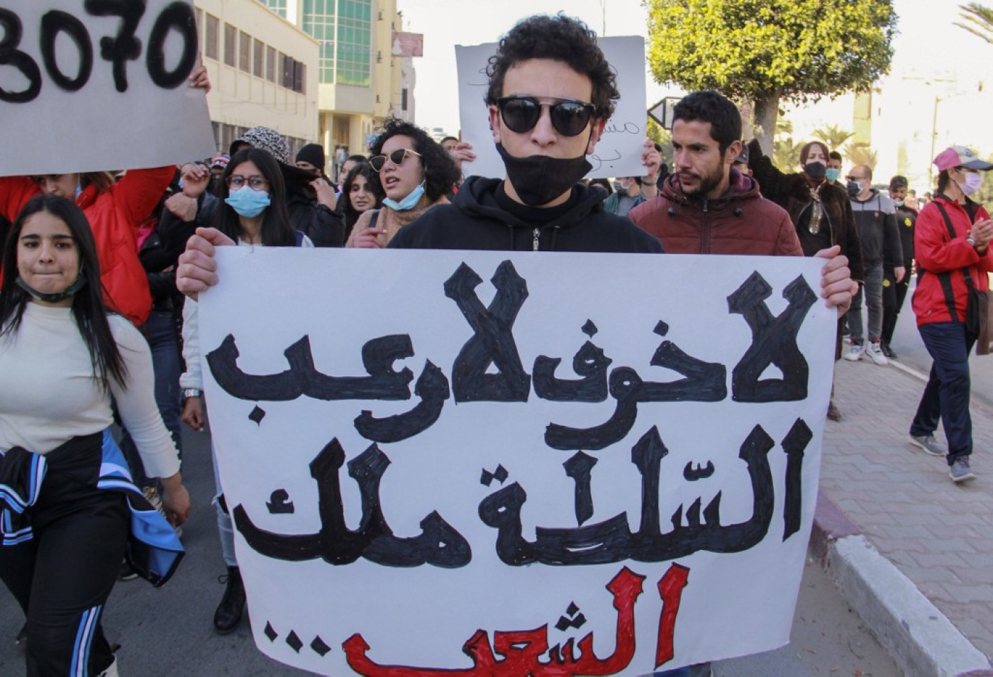 Tunisian protesters lift placards and chant during an anti-government demonstration in the coastal city of Sfax on 19 January 2021.