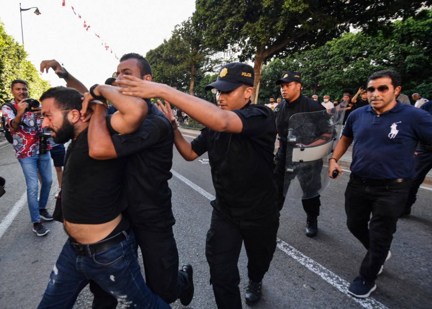 Des policiers tunisiens arrêtent un manifestant le 22 juillet 2022, lors d’une manifestation le long de l’avenue Habib Bourguiba à Tunis, la capitale, contre leur président et le référendum constitutionnel du 25 juillet (AFP/Fethi Belaid)
