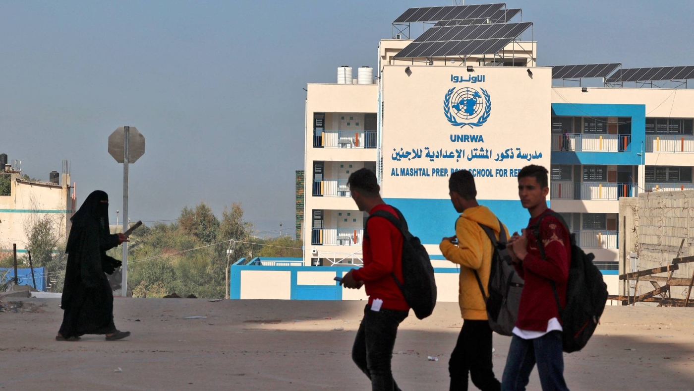 Palestinians walk past the UNRWA's shuttered headquarters in Gaza City during a general strike of employees in UNRWA institutions on 29 November 2021.