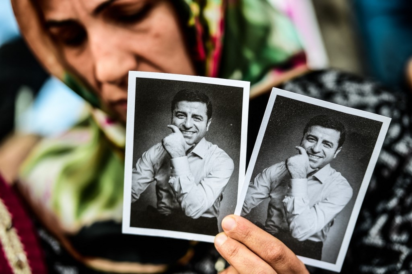 A woman holds pictures of former leader of the pro-Kurdish Peoples' Democratic Party HDP Selahattin Demirtas, in jail for a year and a half, and HDP candidate for the upcoming presidential election, during a rally on May 4, 2018 in Besiktas district of Istanbul. (AFP)