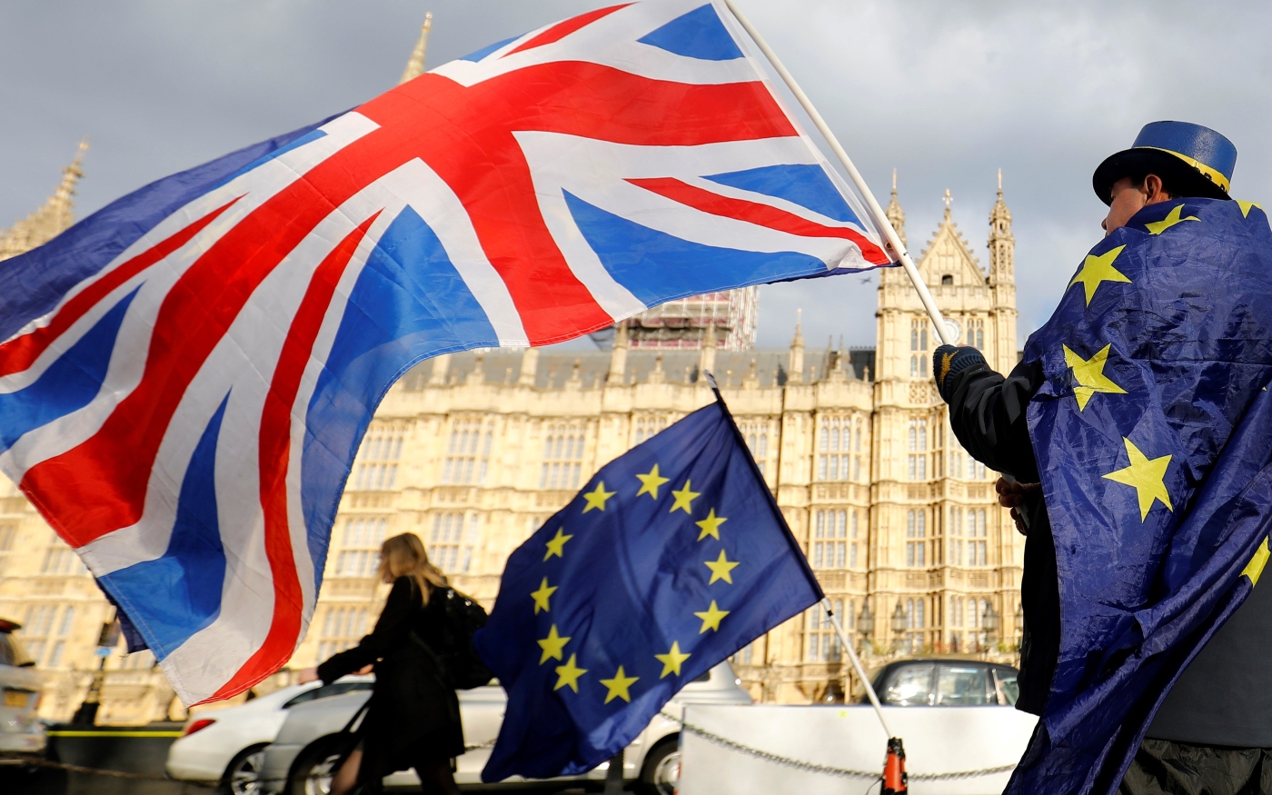 Un manifestant contre le Brexit agite l’Union Jack et un drapeau de l’Union européenne devant les chambres du Parlement à Londres (AFP)