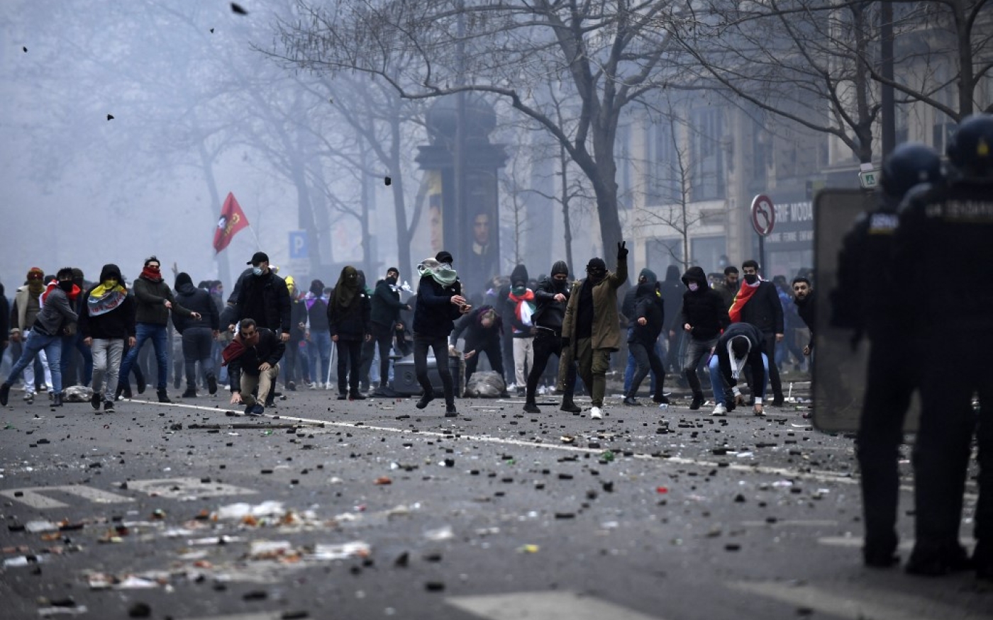 Des manifestants jettent des pierres lors d’affrontements avec la police, suite à une manifestation au lendemain du triple assassinat qui a frappé la communauté kurde à Paris (AFP/Julien De Rosa)