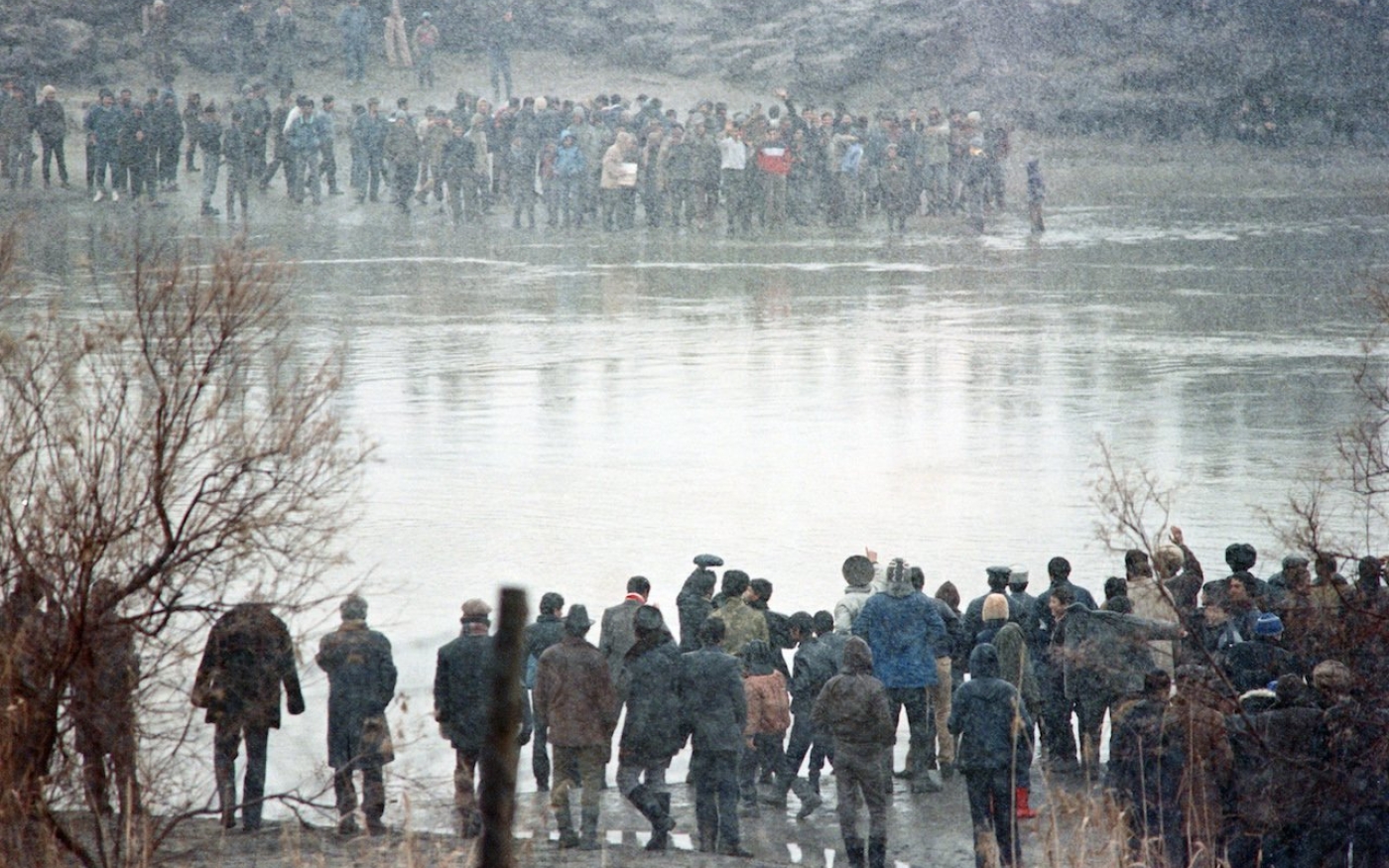 Des Azéris d’Azerbaïdjan saluent des Azéris d’Iran de l’autre côté de l’Araxe, la rivière qui sert de frontière entre les deux pays, le 8 janvier 1990 (AFP)