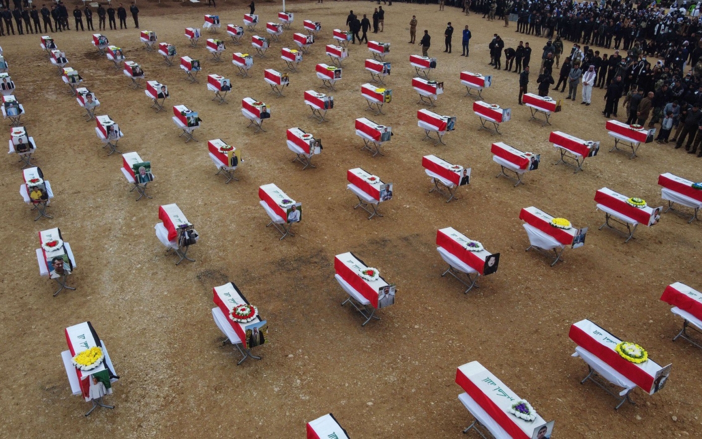 Photo aérienne de cercueils enveloppés du drapeau irakien lors de funérailles collectives en l’honneur de victimes yézidies du groupe État islamique, près de Sinjar (AFP)