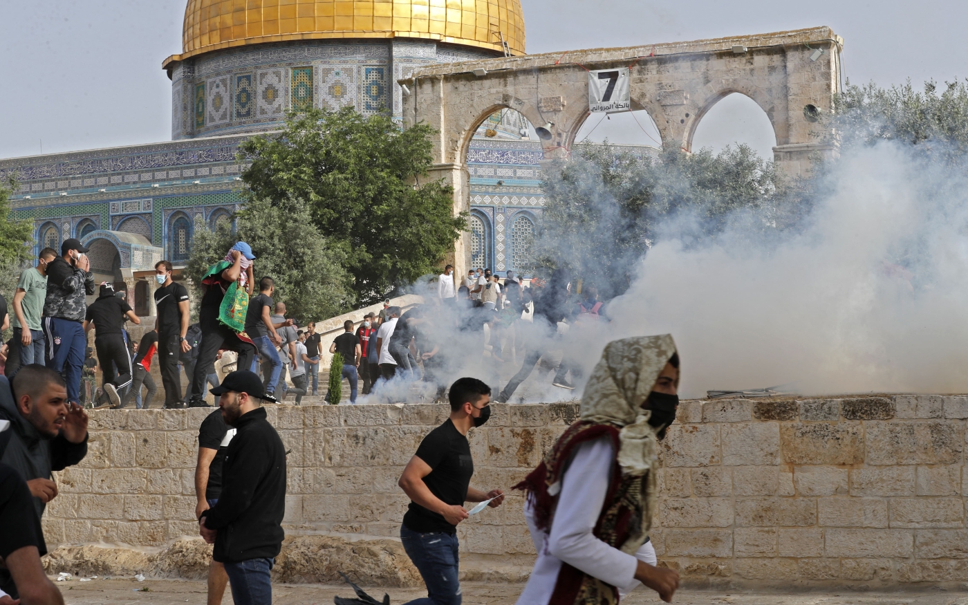 Des Palestiniens courent se mettre à l’abri après des tirs de gaz lacrymogènes dans le complexe de la mosquée al-Aqsa par la police israélienne, le 10 mai 2021 (AFP/Ahmed Gharabli) 