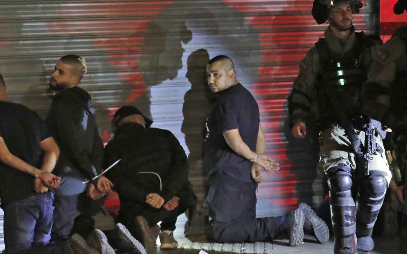 Les forces israéliennes arrêtent un groupe de citoyens palestiniens d’Israël à Lod, le 13 mai, lors d’un saccage par des extrémistes israéliens et des manifestations de Palestiniens (AFP)