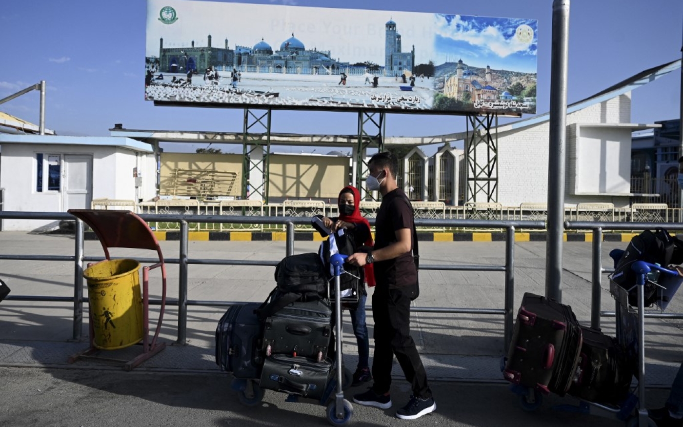 Des Afghans dont les proches travaillent pour la France font la queue pour savoir s’ils peuvent quitter l’Afghanistan, à l’aéroport de Kaboul, le 17 juillet 2021 (AFP/Sajjad Hussain)