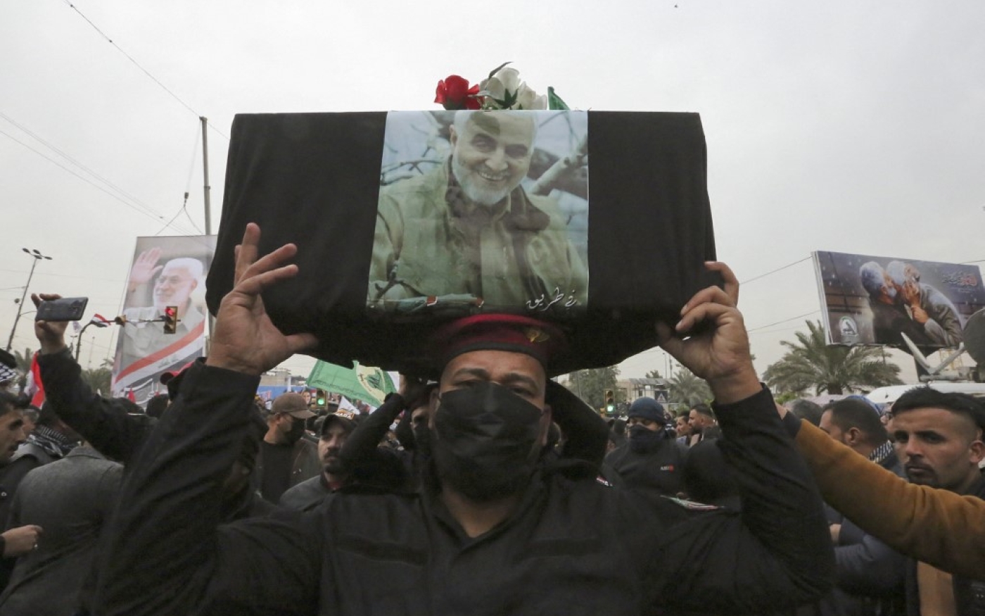 Des partisans de Hachd al-Chaabi soulèvent un faux cercueil lors d’une manifestation pour le deuxième anniversaire de l’assassinat de Qasem Soleimani, à Bagdad, le 1er janvier 2022 (AFP/Sabah Arar)