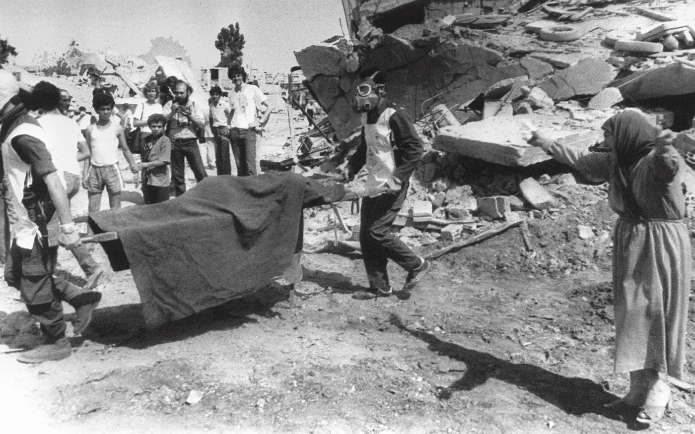 Une femme palestinienne pleure pendant que des agents de la défense civile transportent le corps d'un de ses proches loin des décombres de sa maison dans le camp de Sabra le 19 septembre 1982 (AFP)