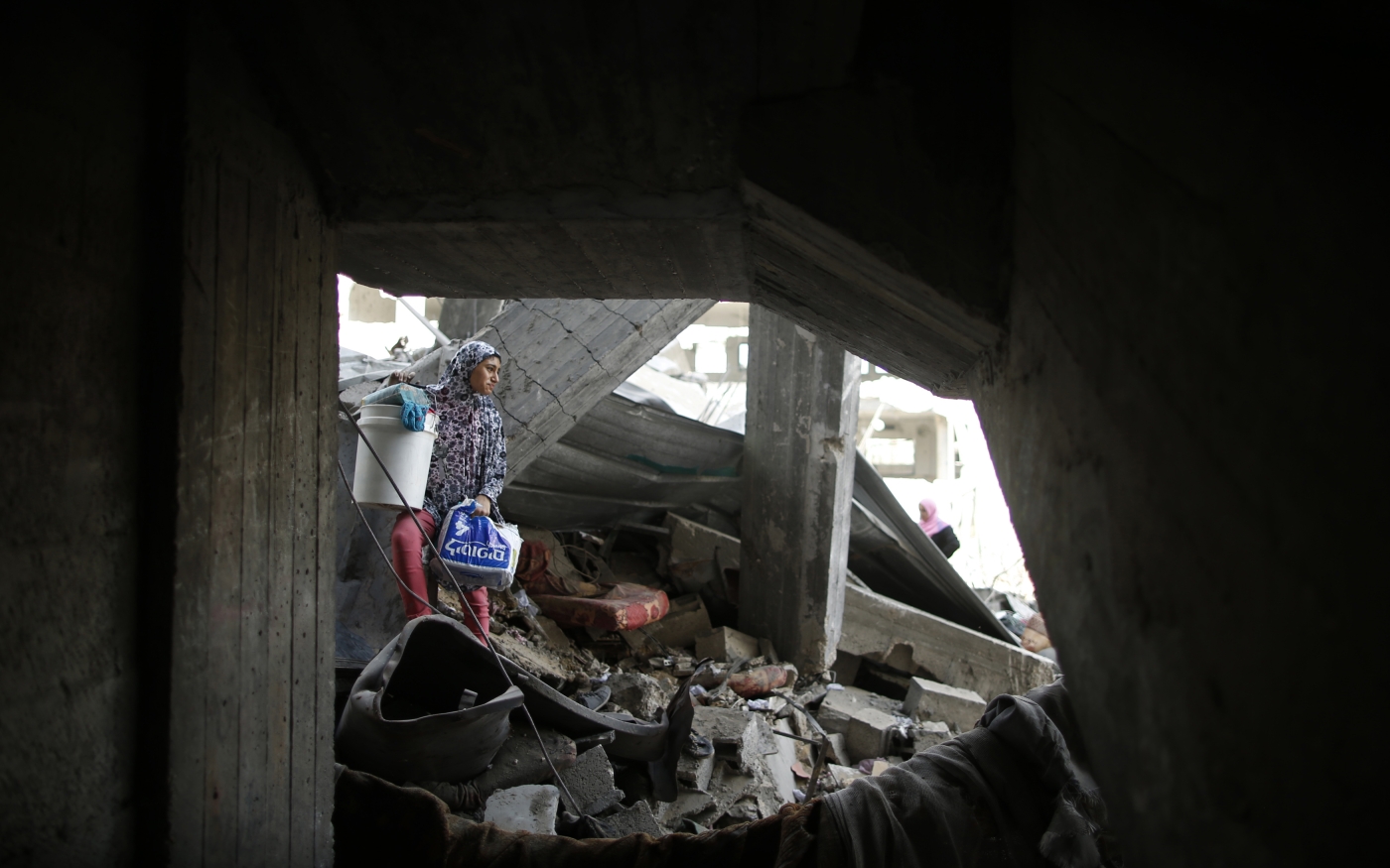Une Palestinienne sort ses effets personnels de la maison familiale détruite dans le quartier de Shujaiya, le 26 juillet 2014 (Reuters)