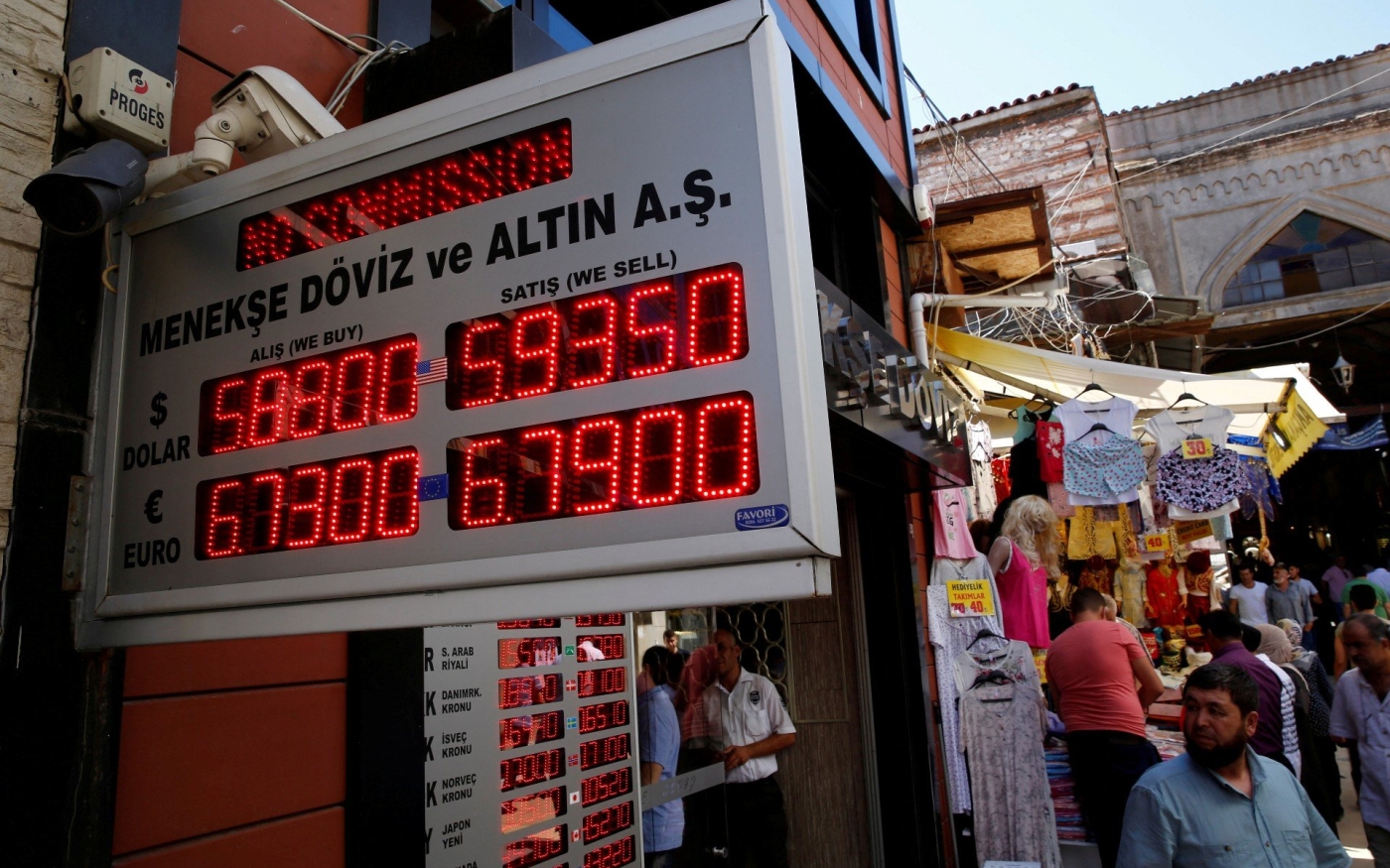 Des clients consultent les taux de change dans un bureau de change à Istanbul (Reuters)