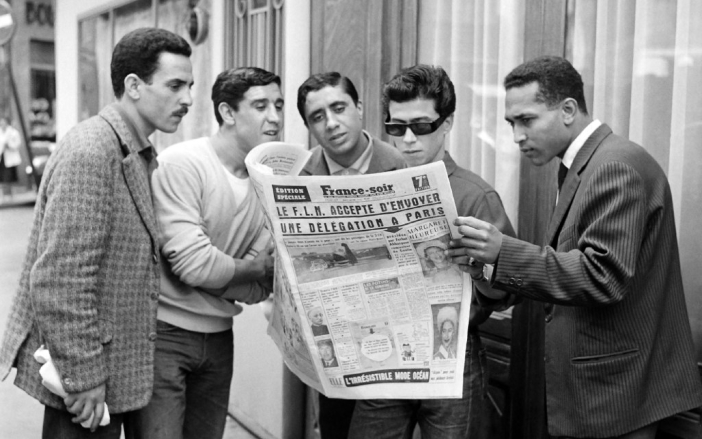 Jeunes algériens à Paris lisant un article sur la décision du GPRA d’envoyer une délégation pour rencontrer le général De Gaulle, 20 juin 1960 (AFP)