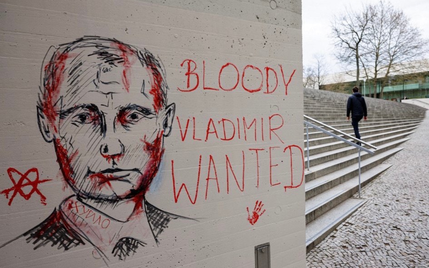 Graffiti représentant le président russe Vladimir Poutine avec l’inscription « Recherché : Vladimir le Sanguinaire » sur un mur à Halle, dans l’est de l’Allemagne, le 20 avril 2022 (AFP)