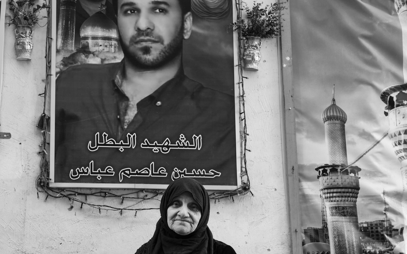 Une Irakienne se trouve à côté du portrait de son fils tombé en martyr, le 25 février 2021 à Bagdad (Nabil Salih)