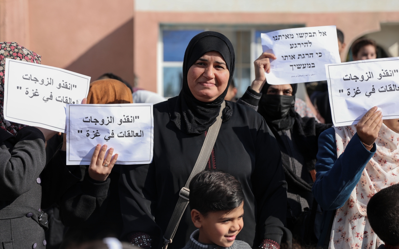Des Palestiniennes brandissent des pancartes en arabe et en hébreu lors d’une manifestation contre la « politique de séparation » d’Israël dans le nord de Gaza, le 17 janvier 2023 (MEE/Mohammed al-Hajjar)