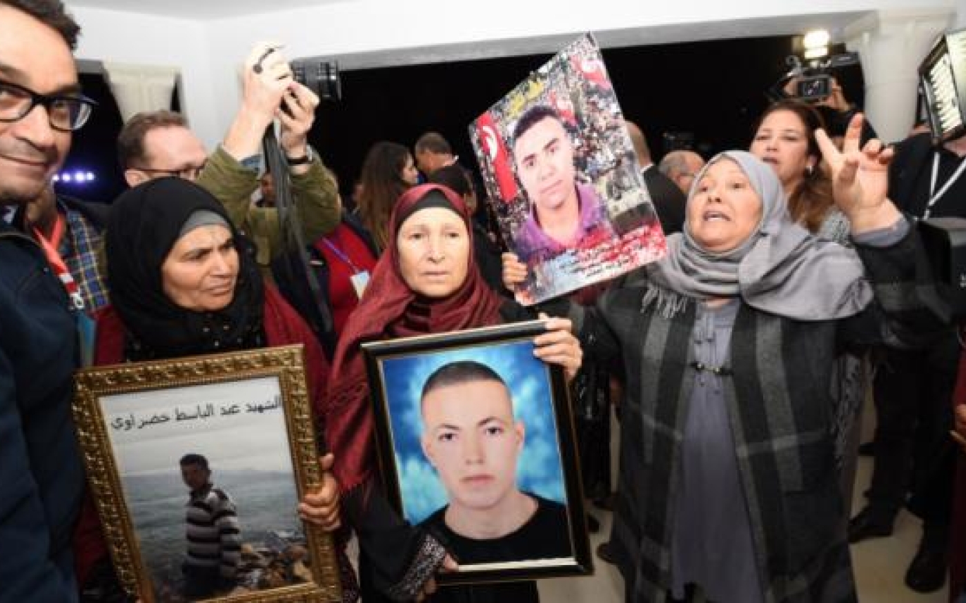 En Tunisie, des mères de victimes de la torture brandissent les portraits de leurs fils à leur arrivée pour une audience devant l’Instance vérité et dignité à Tunis, le 17 novembre 2016 (AFP)