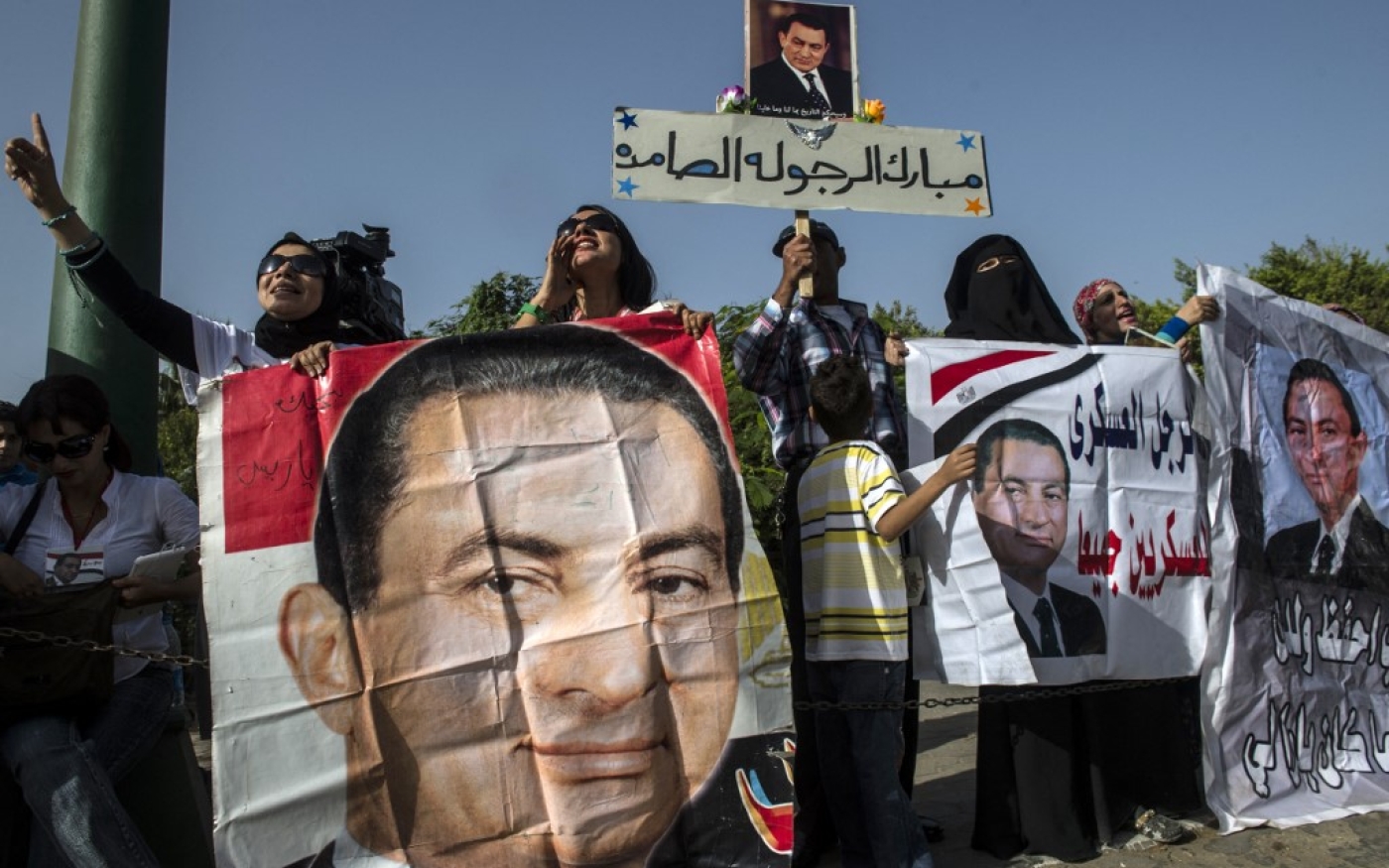 Des Égyptiens tiennent des portraits du président renversé Hosni Moubarak au Caire en 2014 (AFP)