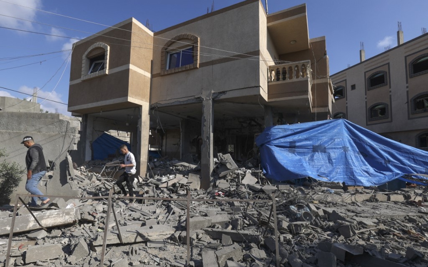Des Palestiniens inspectent la maison fortement endommagée du chef du Jihad islamique, Jihad Ghannam, tué lors d’une frappe aérienne israélienne avant l’aube, à Rafah, dans le sud de la bande de Gaza, le 9 mai 2023 (AFP/Said Khatib