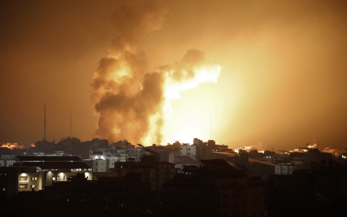 Du feu et de la fumée s’élèvent au-dessus des bâtiments lors d’une frappe aérienne israélienne à Gaza le 8 octobre 2023 (Eyad Baba)