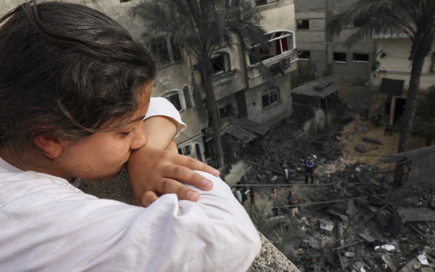 Une Palestinienne regarde les décombres d’un immeuble après une frappe aérienne israélienne, à Beit Lahia, dans le nord de la bande de Gaza, le 11 mai 2023 (AFP/Mohammed Abed)