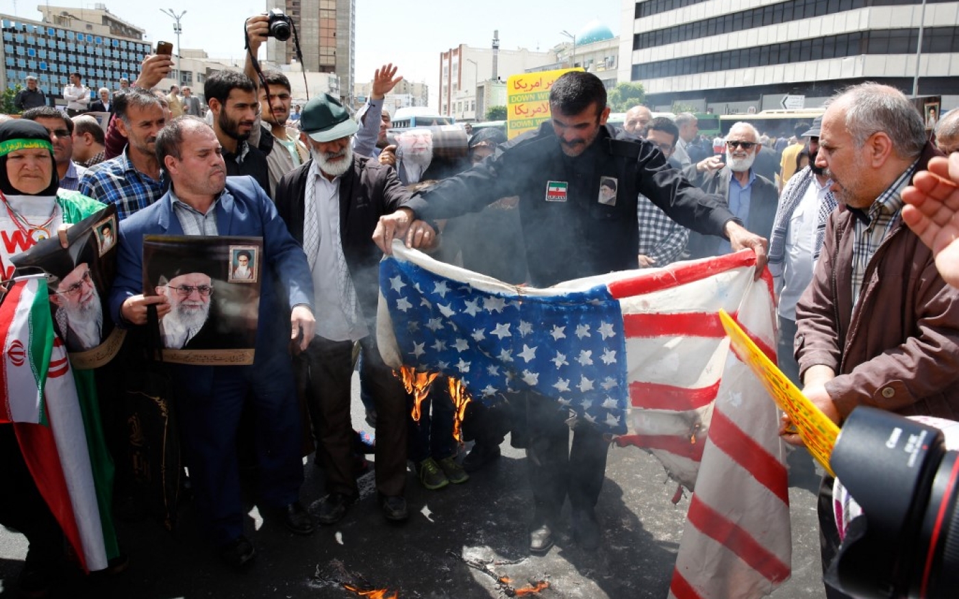 Des manifestants brûlent le drapeau américain lors d’un rassemblement à Téhéran le 10 mai 2019 (AFP)