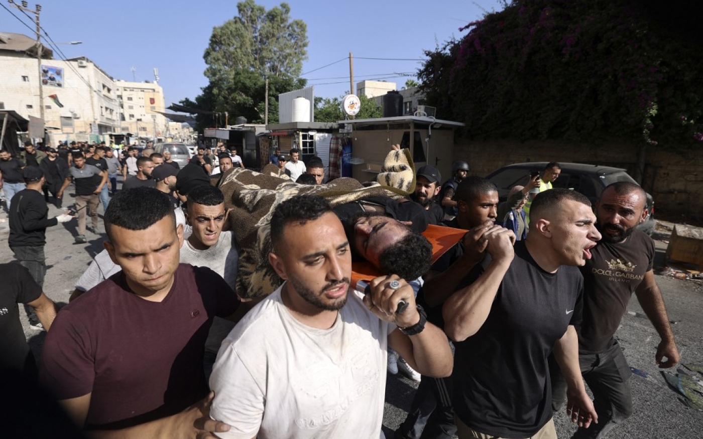 Des hommes portent le corps d’un homme tué lors de l’opération militaire israélienne dans le camp de réfugiés de Jénine, en Cisjordanie occupée, le 4 juillet 2023 (AFP/Jaafar Ashtiyeh)