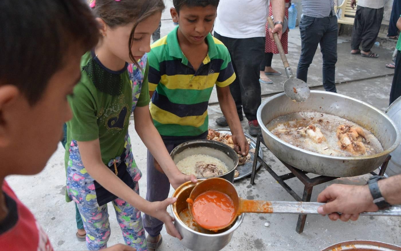 Des membres d’une organisation caritative irakienne distribuent de la nourriture à Mossoul, en mai 2018 (AFP)