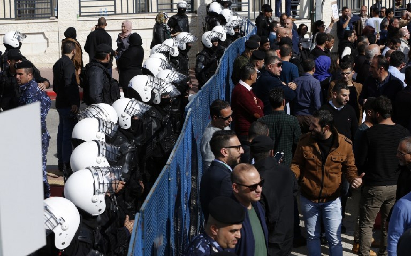 Les forces de sécurité palestiniennes forment un bouclier humain alors que les manifestants protestent contre le projet de loi sur la sécurité sociale de l’AP (AFP)