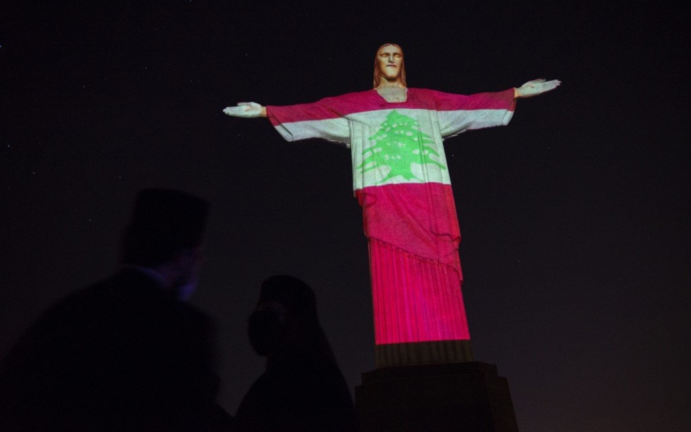 La statue du Christ Rédempteur drapée de l’étendard libanais illuminée en hommage aux victimes de l’explosion du port de Beyrouth en 2020 (Reuters)