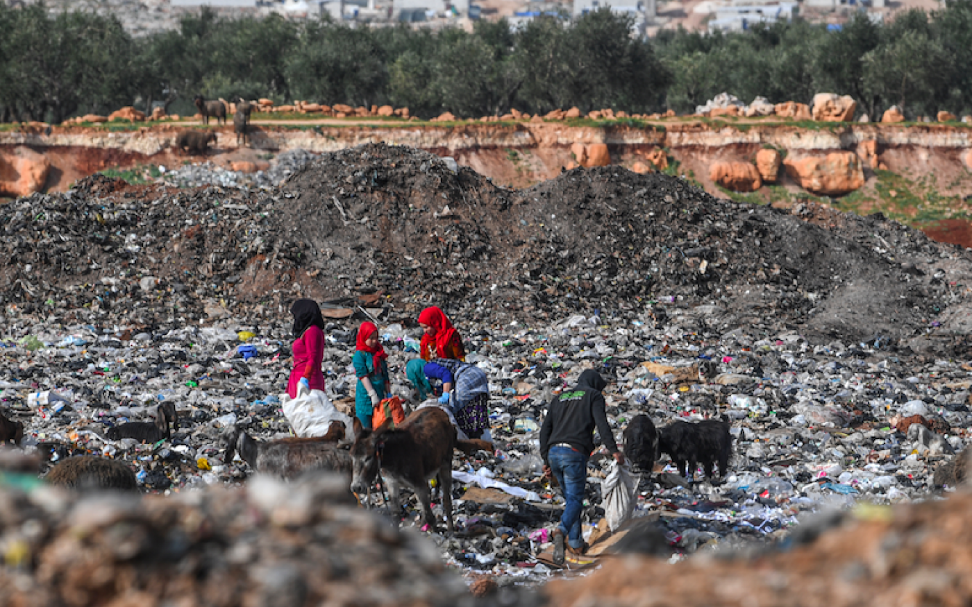 Des Syriens fouillent dans les ordures d'une décharge près d'un camp de personnes déplacées dans le village de Kafr Lusin dans la province d'Idlib (AFP)
