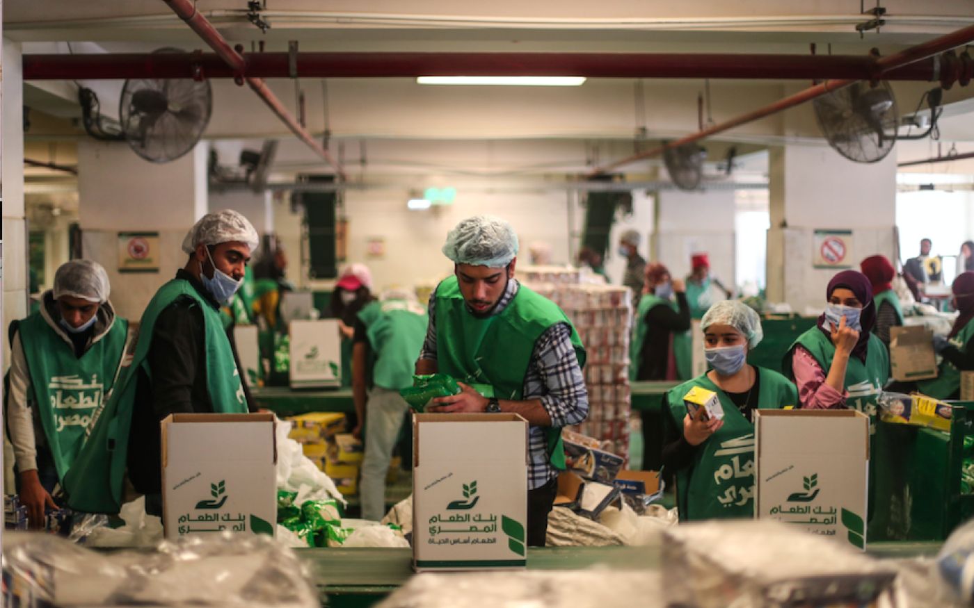 Des bénévoles préparent des colis alimentaires dans le centre de l'ONG Egyptian Food Bank, au Caire, le 5 avril 2020 (AFP)