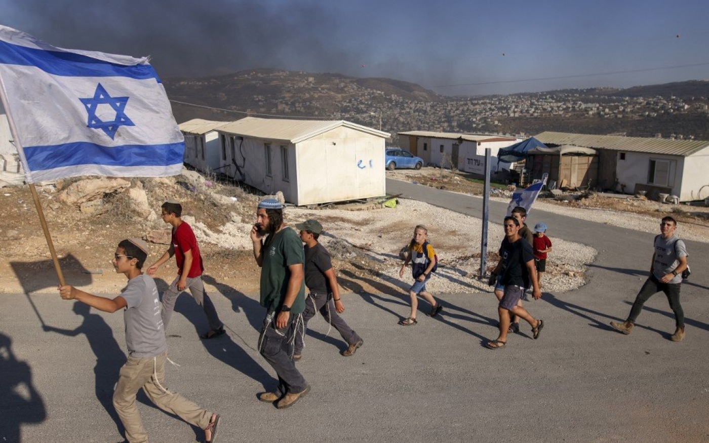 Des colons israéliens défilent dans un nouvel avant-poste (colonie illégale selon le droit israélien) en Cisjordanie occupée, le 21 juin 2021 (AFP)