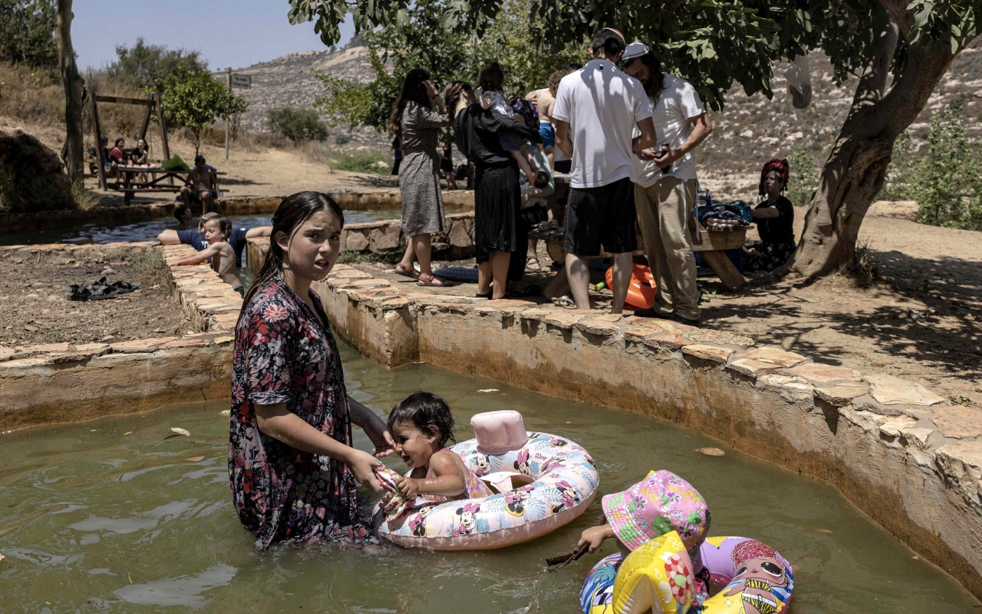 Des colons jouent dans une source d’eau au nord de Ramallah, en Cisjordanie occupée (AFP/Menahem Kahana)